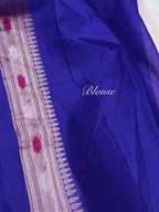 A close-up of a royal blue fabric, likely a saree, featuring a detailed gold and pink patterned border on the left and a white script watermark reading 'Blouse' in the center.